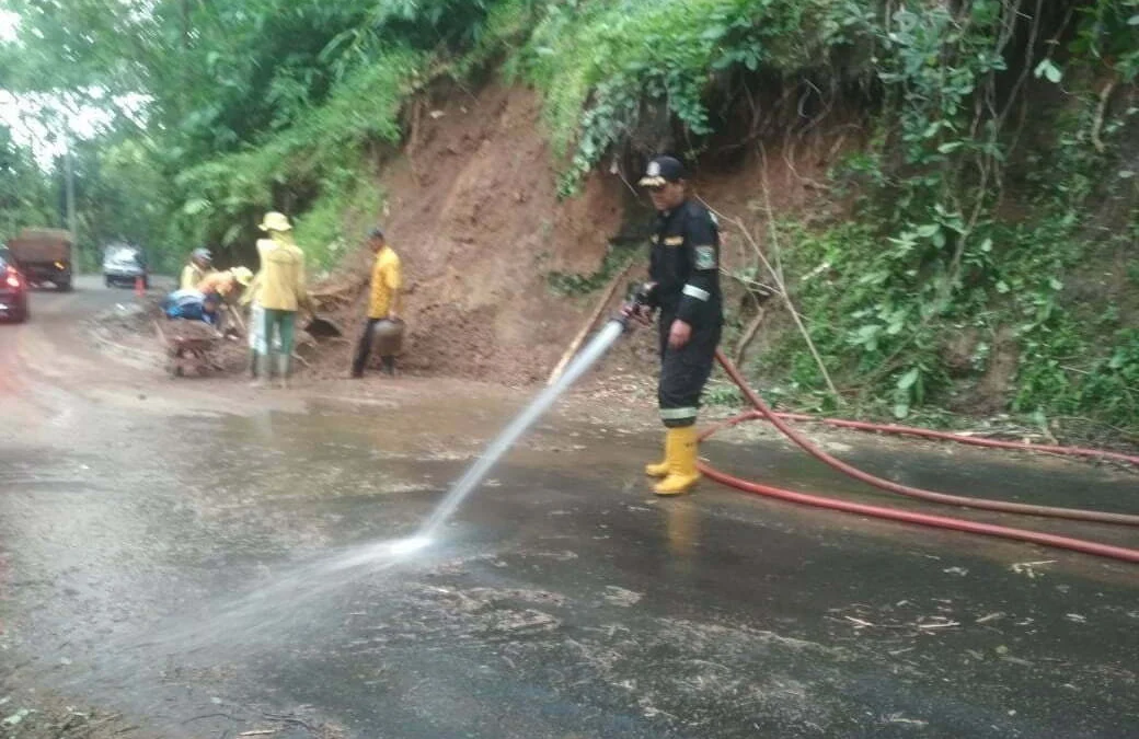 Petugas Damkar Bersihkan Jalan Raya Cileuya