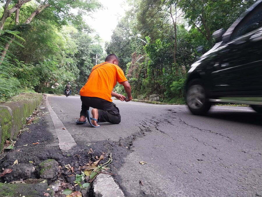 Anggota BPBD Kabupaten Cirebon Fauzan mengecek keretakan di Jalan Pelangon Desa Babakan Kecamatan Sumber