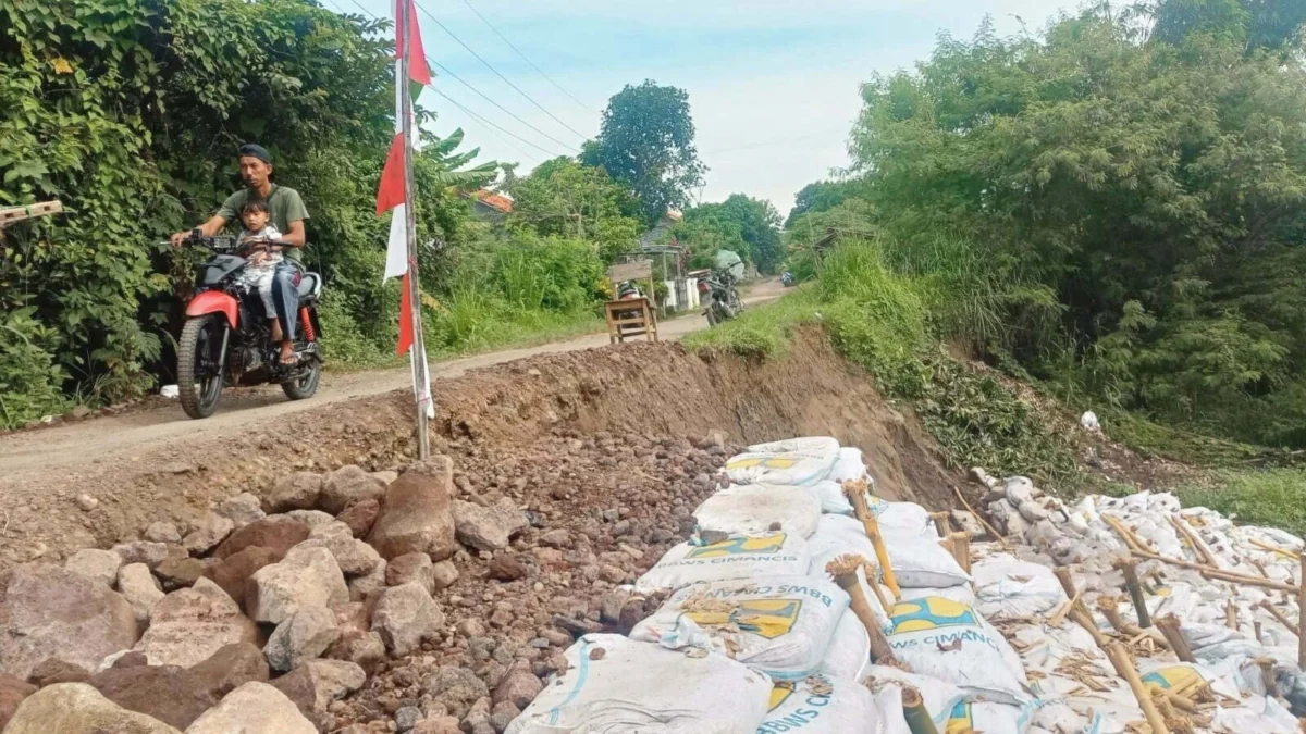 Jalan tergerus air Sungai Cikeruh di Blok Puteran, Desa Ligung Lor, Kecamatan Ligung. Erosi telah menggerus sebagian badan jalan desa yang selama ini menjadi akses utama bagi warga dari tiga desa