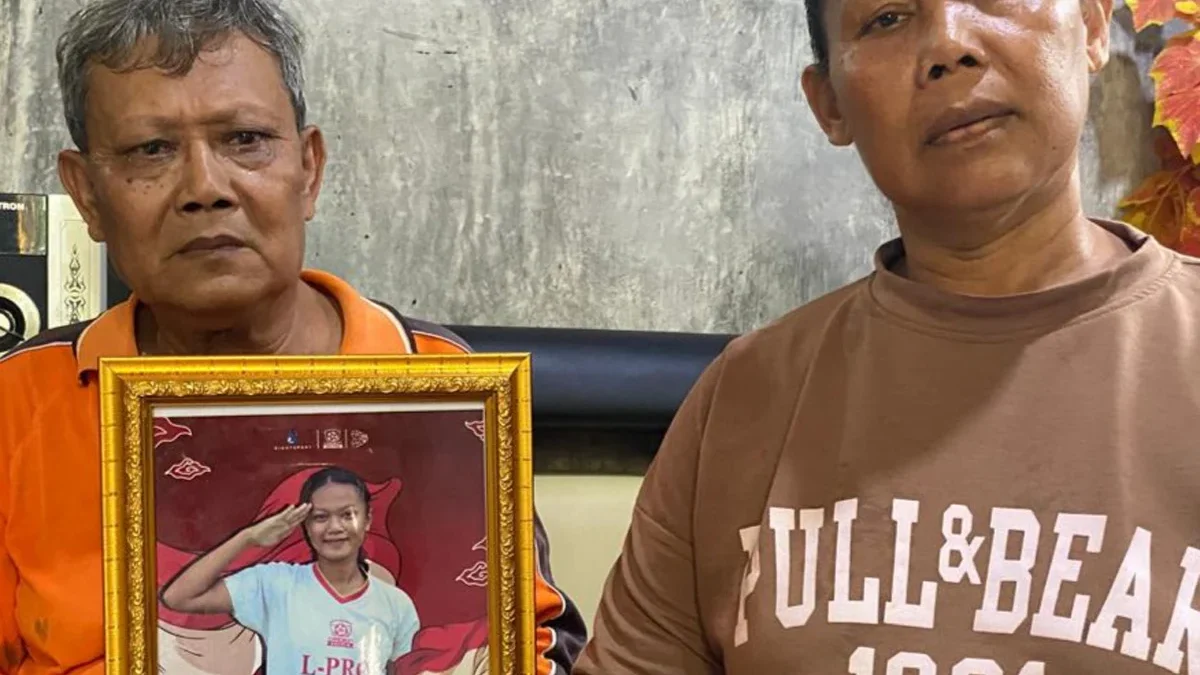 Kedua orang tua Nanda Rahmawati memperlihatkan foto Nanda yang dipanggil timnas Indonesia berlaga di Piala Asi