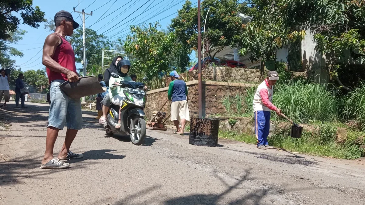 Warga Desa Jatipancur Kecamatan Greged melakukan penambalan jalan yang rusak dengan cara swadaya.