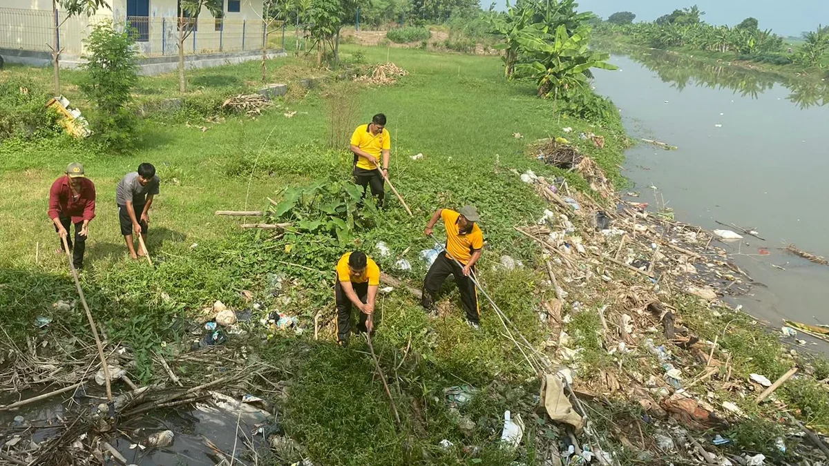 Anggota Polsek Gegesik dan masyarakat membersihkan sampah dan eceng gondok di Sungai Sigodong.
